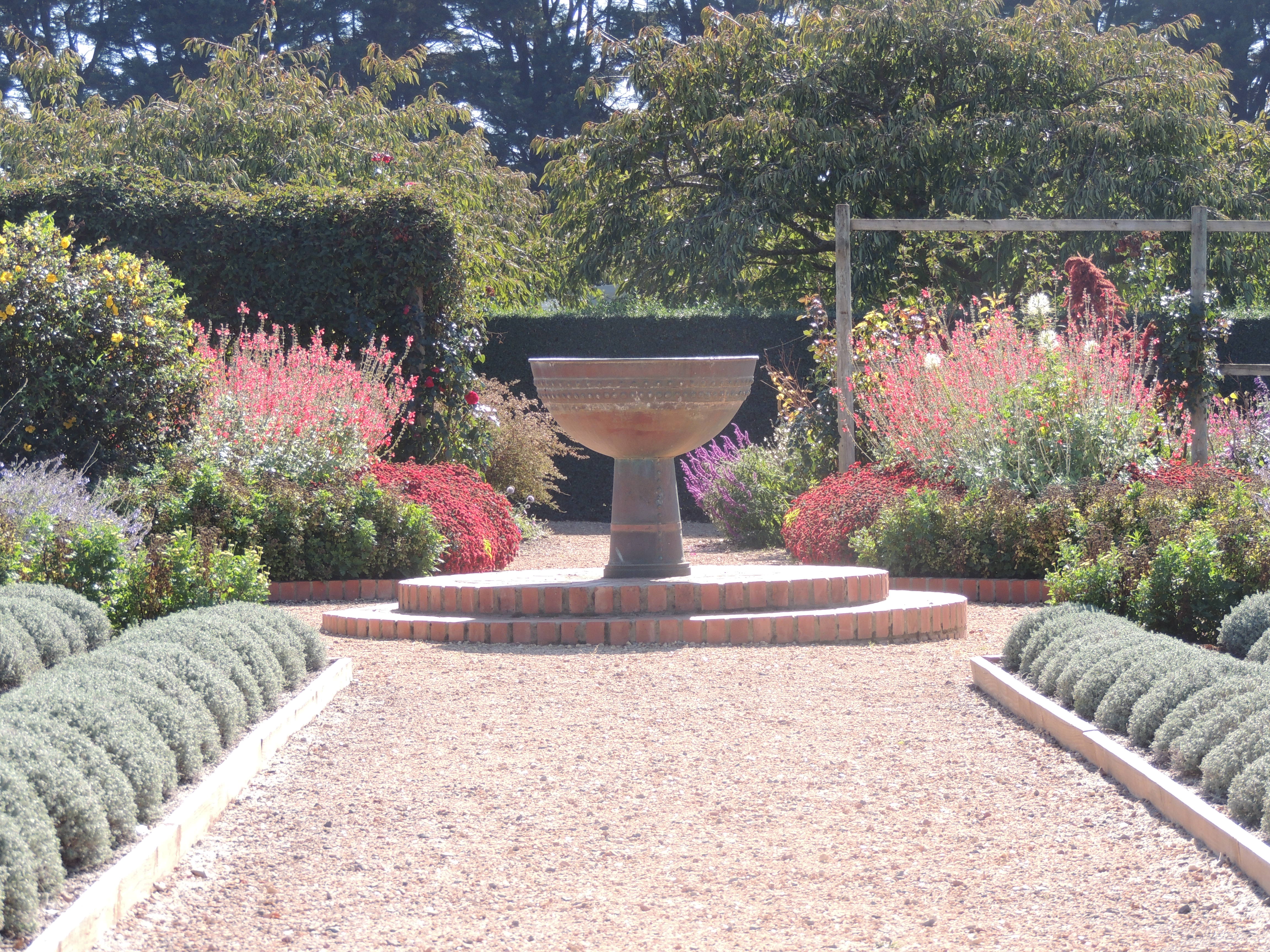 And looking at the urn from the opposite direction, the visitor sees a much more formal aspect with carefully clipped hedges flanking an immaculate path.